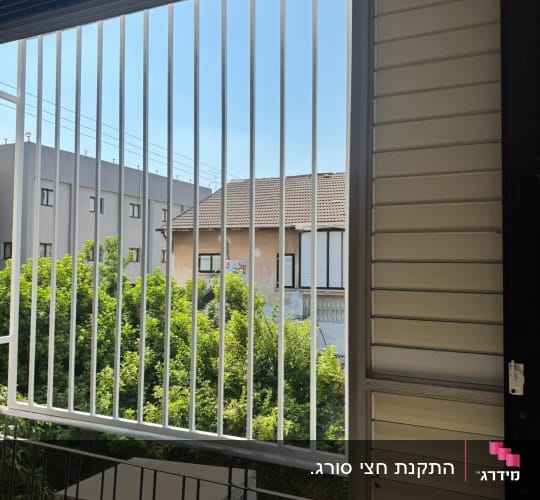 סורגים ישרים ממתכת בצבע לבן בחלון מרפסת